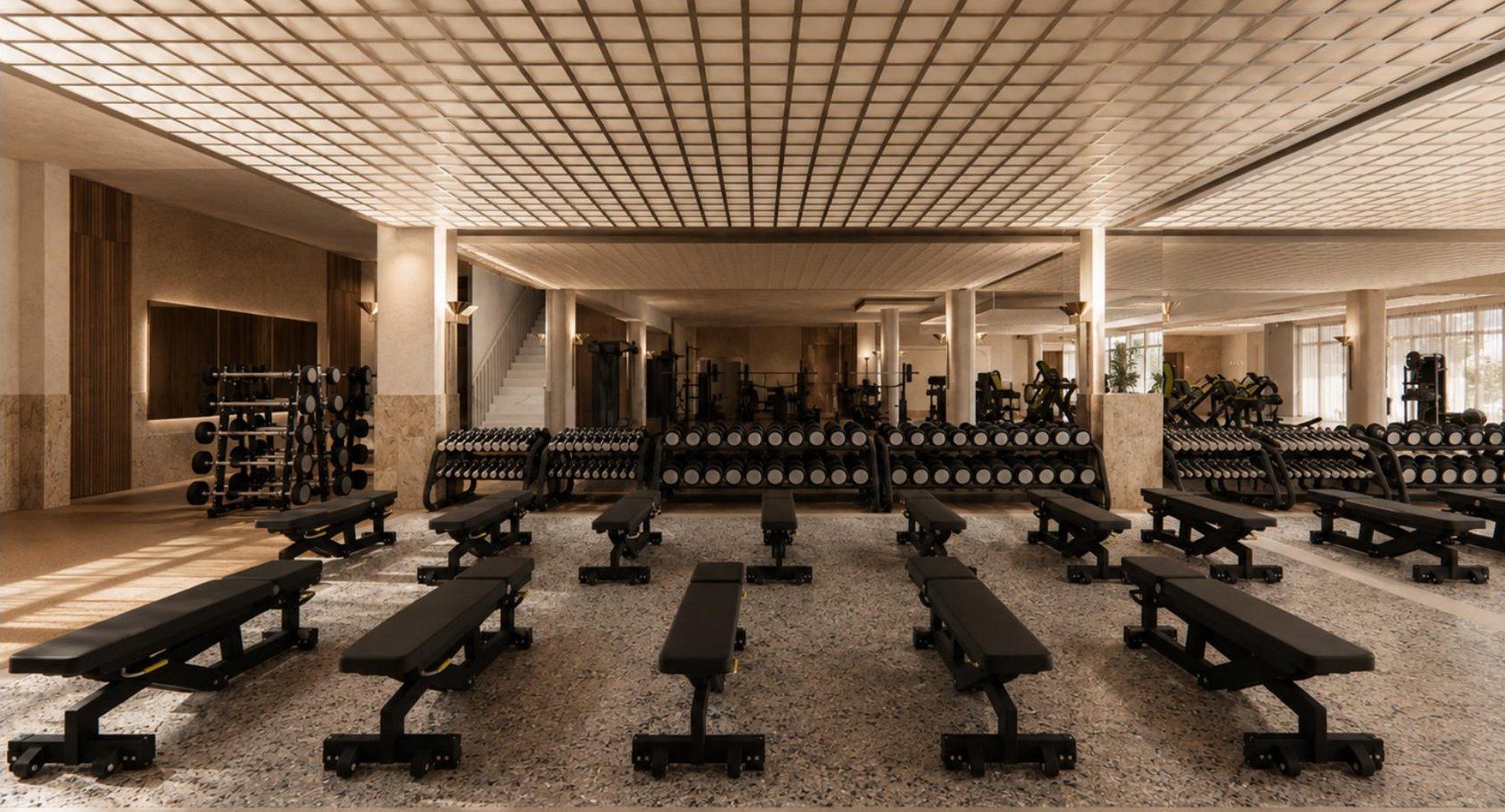 The free weights hall under a lit ceiling grid